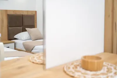 a reflection of a bedroom with a bed and a mirror at GAVIA Apartments - Ulcinj in Ulcinj
