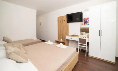 a small bedroom with a bed and a kitchen at GAVIA Apartments - Ulcinj in Ulcinj