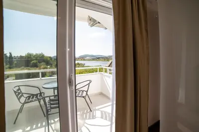 a room with a balcony with a table and chairs at GAVIA Apartments - Ulcinj in Ulcinj