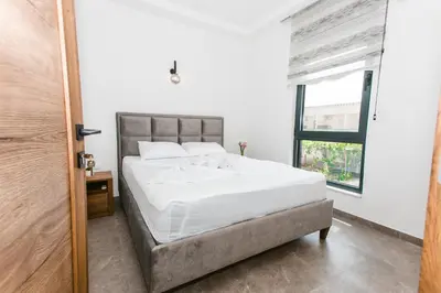 a bedroom with a white bed and a window at Bumax Apartments in Ulcinj