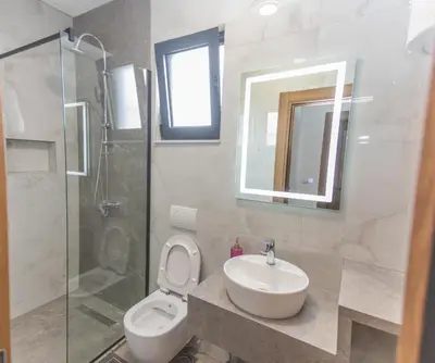 a bathroom with a toilet and a sink and a shower at Bumax Apartments in Ulcinj