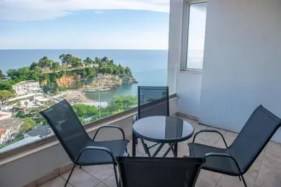 a balcony with a table and chairs and a view of the ocean at BigBen Apartments in Ulcinj