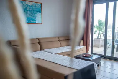a living room with a couch and a large window at BigBen Apartments in Ulcinj