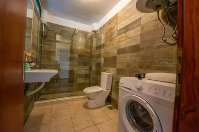 a bathroom with a toilet and a washing machine at BigBen Apartments in Ulcinj