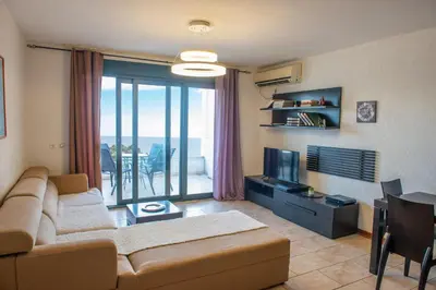 a living room with a couch and a television at BigBen Apartments in Ulcinj