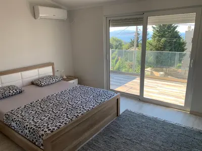 a bedroom with a bed and a large window at Villa DanDan Sutomore in Zagrađe