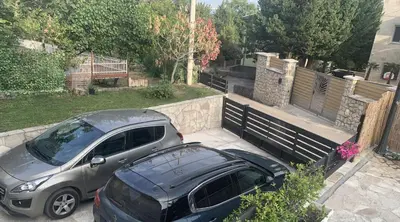 two cars parked in a driveway next to a fence at Villa DanDan Sutomore in Zagrađe