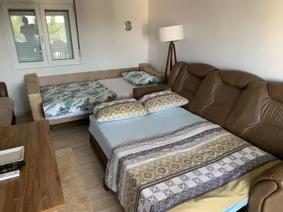 a living room with a couch and a bed at Villa DanDan Sutomore in Zagrađe