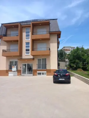 a black car parked in front of a building at Big Fashion - Central Point in Podgorica