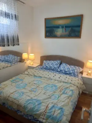 a bedroom with a bed and two lamps and a window at Big Fashion - Central Point in Podgorica