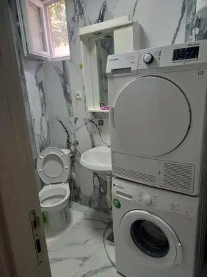 a bathroom with a washing machine and a toilet at Big Fashion - Central Point in Podgorica
