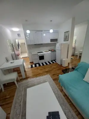 a living room with a couch and a kitchen at Big Fashion - Central Point in Podgorica