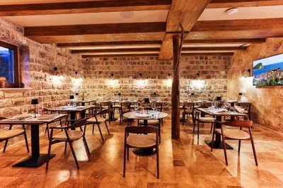 a restaurant with tables and chairs in a brick wall at Boutique hotel Ruzmarin SPA & Garden by Aycon in Budva