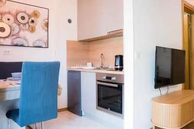 a small kitchen with a blue chair and a table at Apartman Palma, Budva in Budva