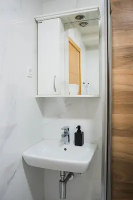 a white bathroom with a sink and a mirror at Apartman Palma, Budva in Budva