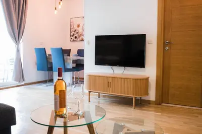 a living room with a bottle of wine on a table at Apartman Palma, Budva in Budva