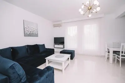 a living room with a black couch and a table at CORONA Apartments in Ulcinj