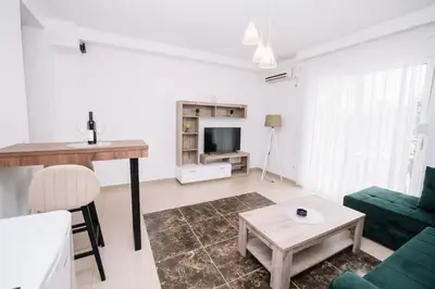 a living room with a green couch and a table at CORONA Apartments in Ulcinj