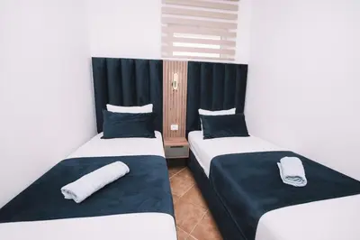 two beds in a room with black and white at CORONA Apartments in Ulcinj