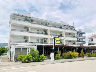 a large white building with a sign in front of it at CORONA Apartments in Ulcinj