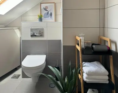 a bathroom with a toilet and a plant in it at SunJourney Apartment SEA view in Becici