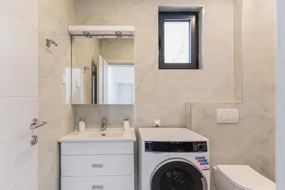 a bathroom with a washing machine and a sink at Family House Giardino Verde in Bar