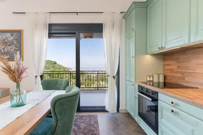a kitchen with a table and a view of a balcony at Family House Giardino Verde in Bar