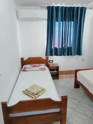 a small room with a bed and a window at Apartmanes Volaric M in Sutomore