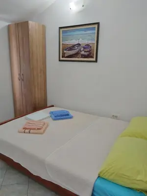 a bedroom with a bed with towels on it at Apartmanes Volaric M in Sutomore