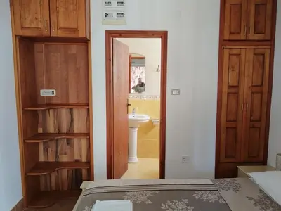 a bedroom with a bathroom with a sink and a door at Apartmanes Volaric M in Sutomore