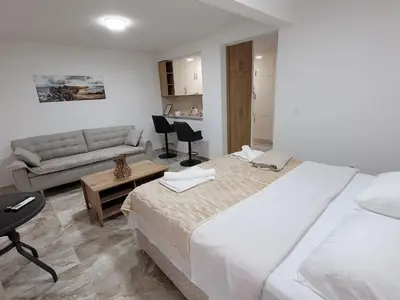 a hotel room with two beds and a couch at Montenegro Apartments Phoenix With Pool in Bar