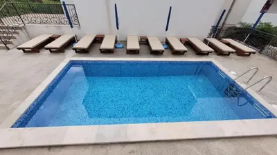 a swimming pool with benches and a table and a pool at Montenegro Apartments Phoenix With Pool in Bar