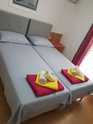 two beds in a room with towels on them at Helen's apartments in Budva