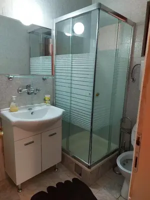 a bathroom with a glass shower and a sink at Helen's apartments in Budva