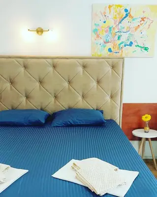a bed with blue sheets and blue pillows at Helen's apartments in Budva