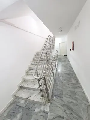 a staircase in a room with white walls and marble floors at Status-M Apartments Irysh in Becici