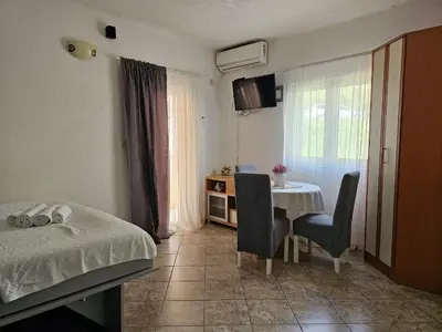 a bedroom with a bed and a table with chairs at Apartments Carpe Diem in Kotor