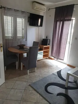 a living room with a table and a dining room at Apartments Carpe Diem in Kotor