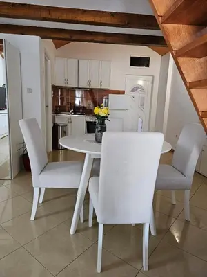 a white dining room table with chairs and a kitchen at Apartments Carpe Diem in Kotor
