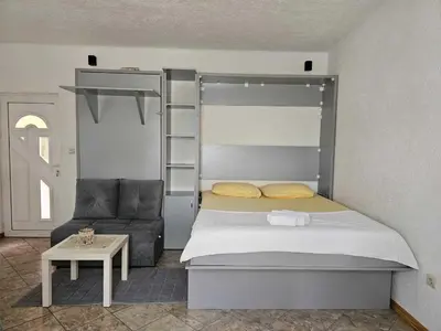 a bedroom with a bunk bed and a couch at Apartments Carpe Diem in Kotor