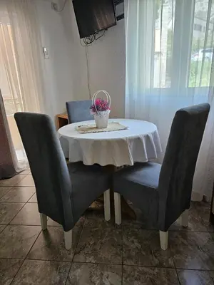 a table with two chairs and a vase of flowers on it at Apartments Carpe Diem in Kotor