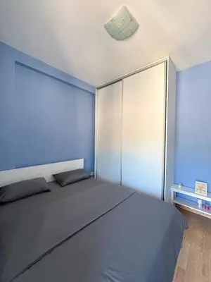 a bedroom with a large bed and a blue wall at Charming Stay in Budva Center with Parking in Budva