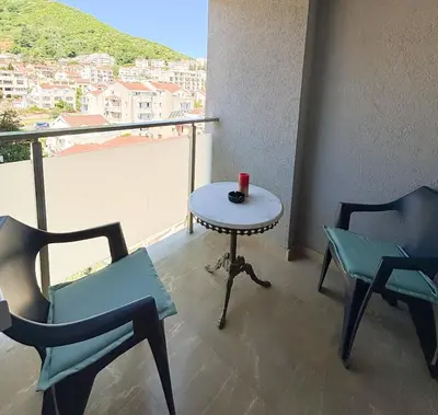a table and chairs in a room with a balcony at Charming Stay in Budva Center with Parking in Budva