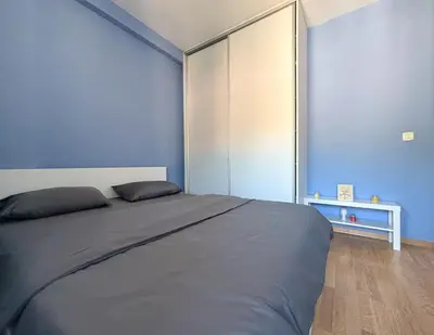 a bedroom with a large bed with blue walls at Charming Stay in Budva Center with Parking in Budva