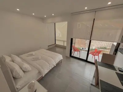 a bedroom with a white bed and a table and chairs at Absolute Adriatic in Kotor