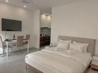 a bedroom with a bed and a desk and a kitchen at Absolute Adriatic in Kotor