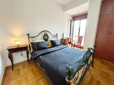 a bedroom with a bed with a blue comforter at Heart of the City Stunning comfort,Balcony ,Netflix,Free Wi-Fi in Podgorica