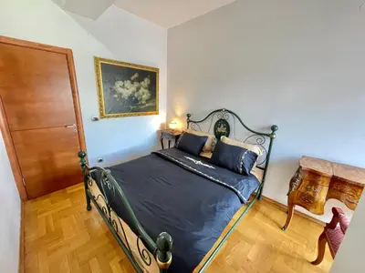 a bedroom with a bed with blue sheets and a wooden floor at Heart of the City Stunning comfort,Balcony ,Netflix,Free Wi-Fi in Podgorica