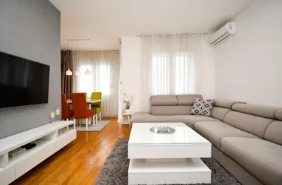 a living room with a couch and a tv at Comfort Residence Art Zone in Podgorica