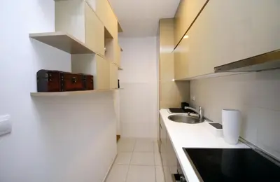 a small white kitchen with a sink and a counter at Comfort Residence Art Zone in Podgorica